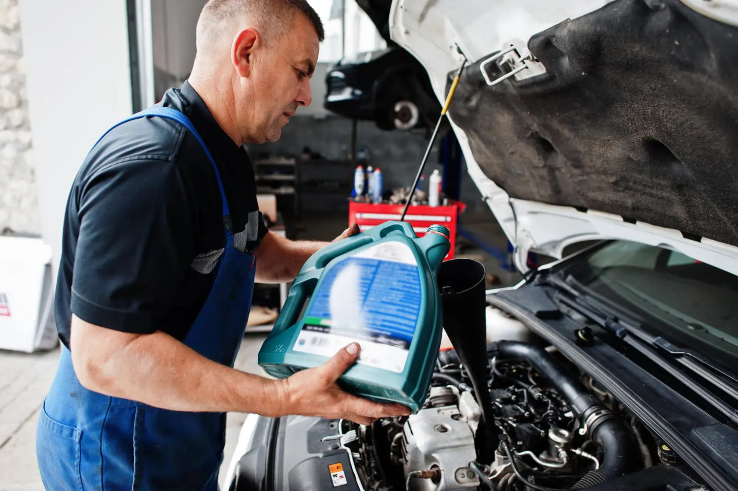 Auto technician performs a synthetic oil change to maintain proper engine health