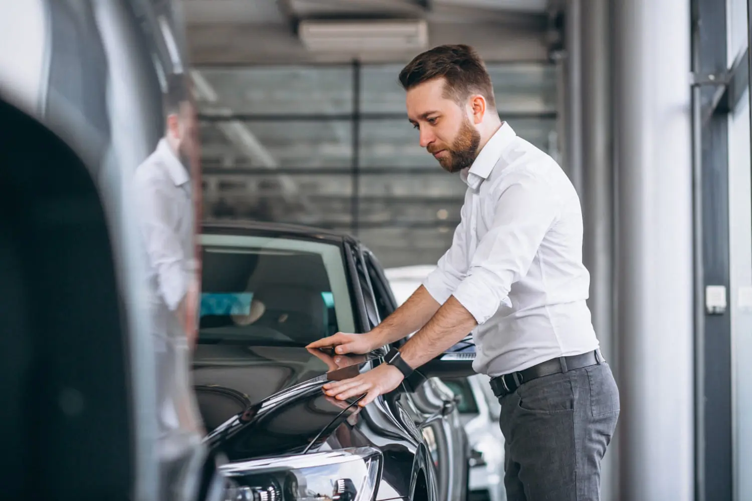 Car dealer inspecting a vehicle as auto brand mergers reshape buyer choices soon