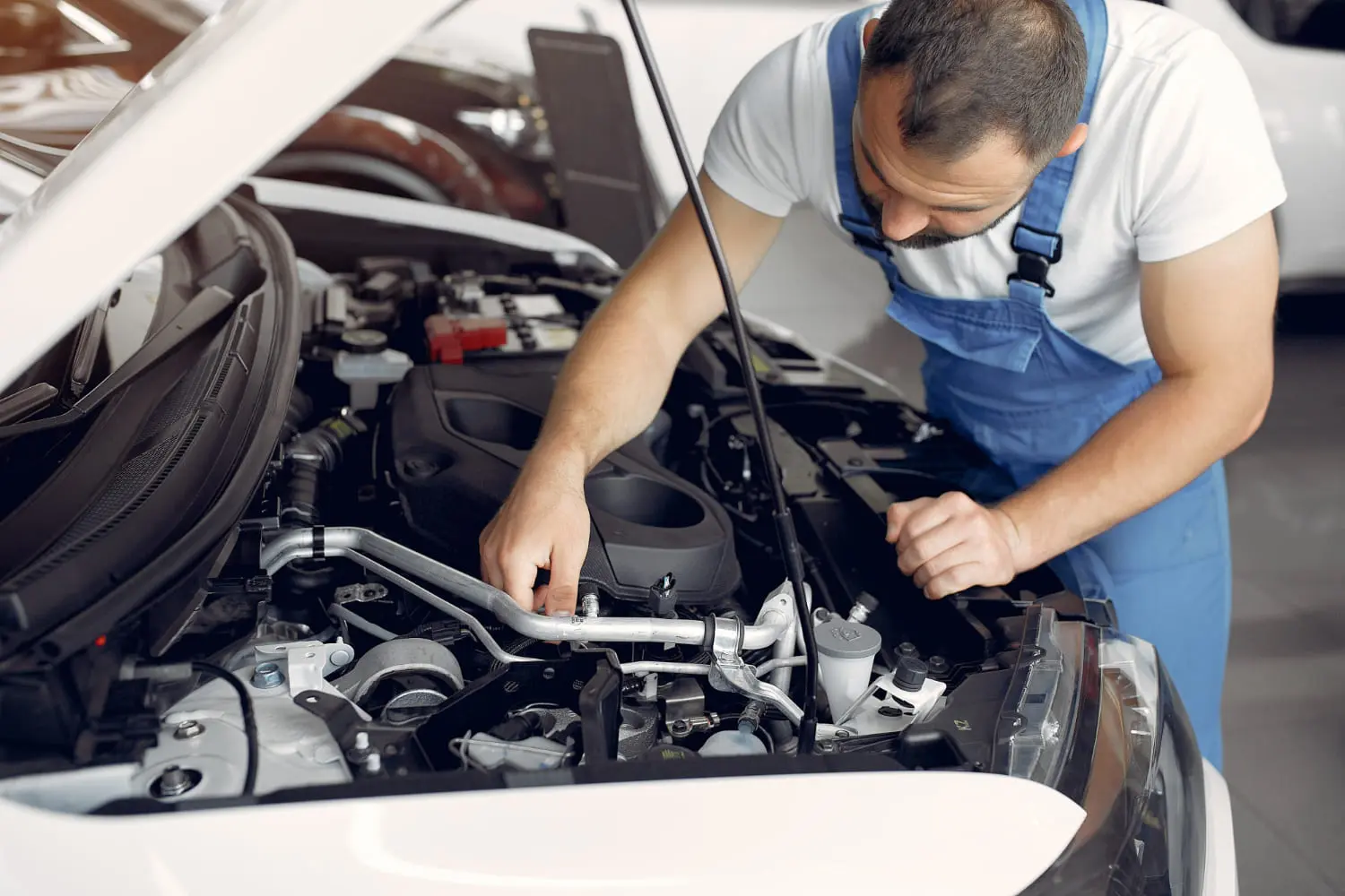 Mechanic examining a car engine to compare turbo vs naturally aspirated lifespan
