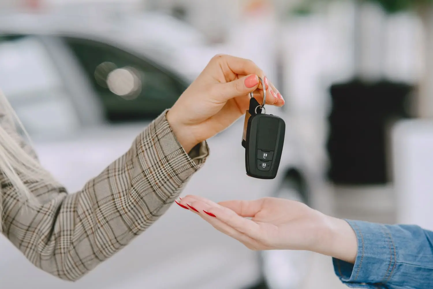 Buyer receiving car keys after finalizing an out-of-state used car purchase deal