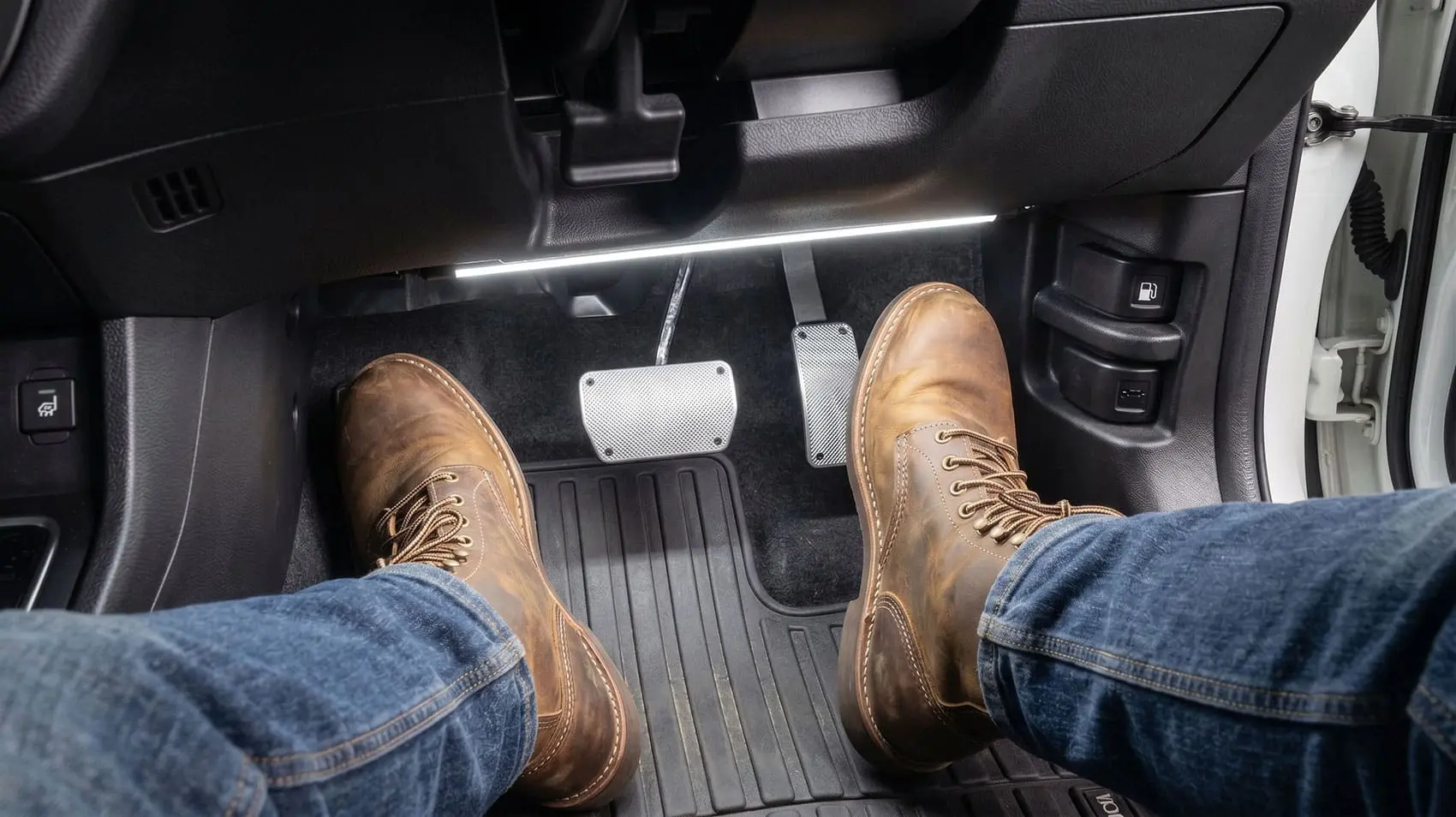 Driver's foot on car brake pedal to fix sticky pedal issue and avoid a collision