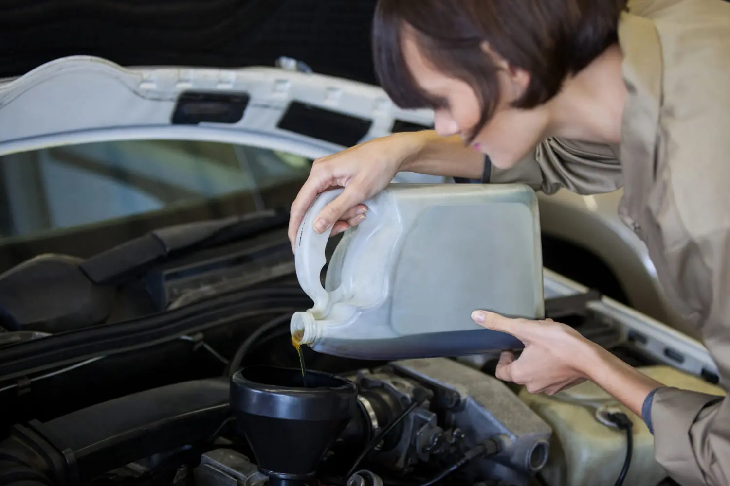 Pouring oil into an engine highlights when to switch to high-mileage oil service